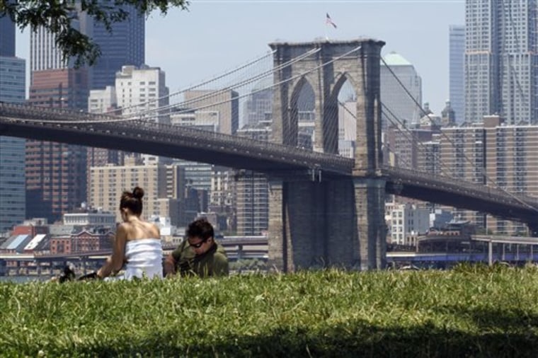 A couple relaxes in the shade at Brooklyn Bridge Park on July 5, 2010, in the Brooklyn borough of New York. Americans are increasingly ditching the staycation for a short-stay getaway.